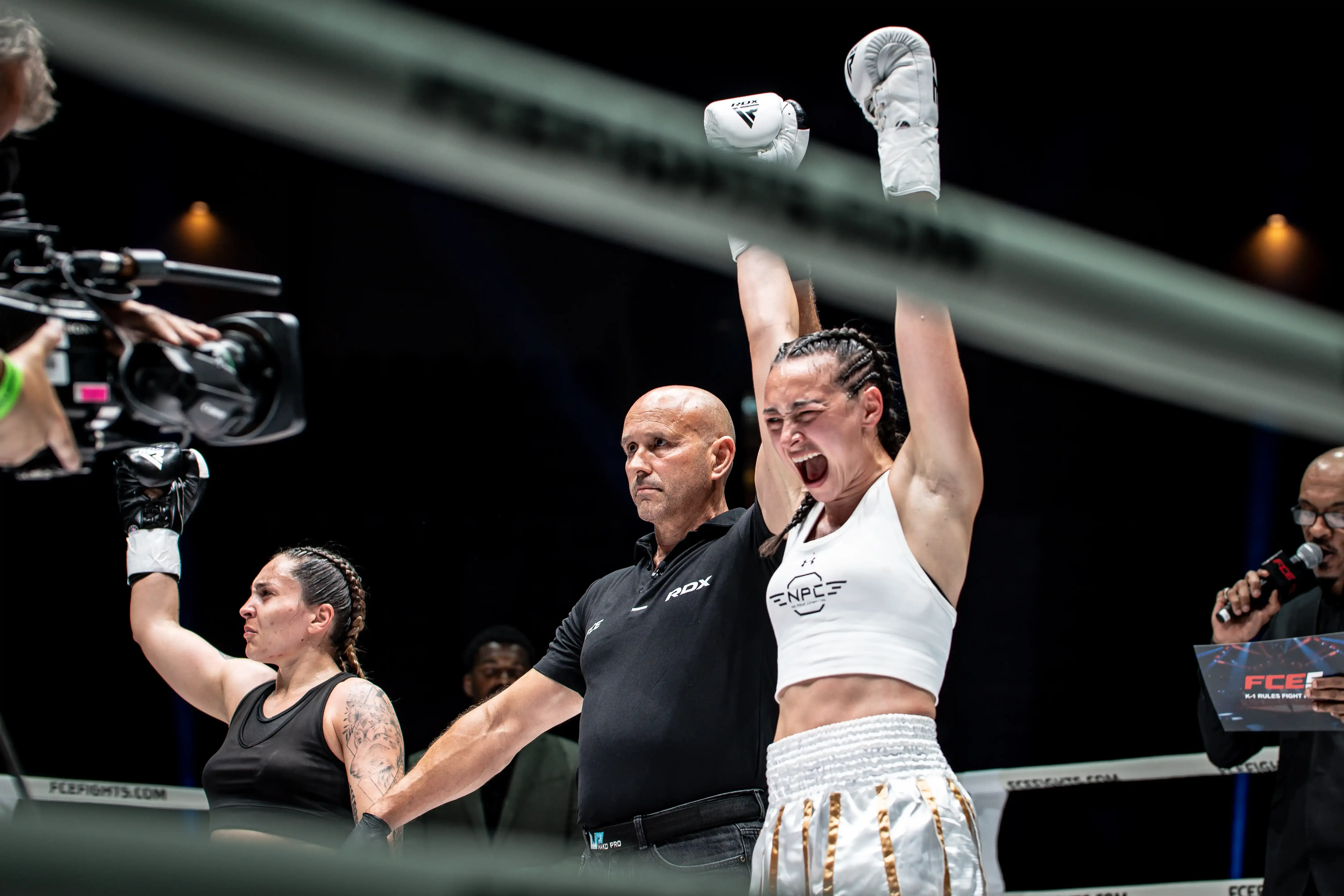 Thomas raises her hands after winning the fight with Daniela